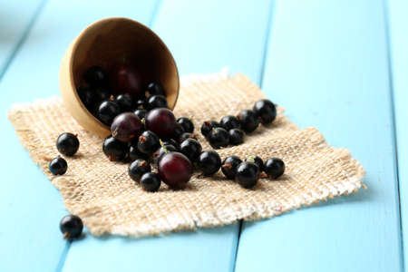 Ripe blackcurrants in bowl on wooden background.の写真素材