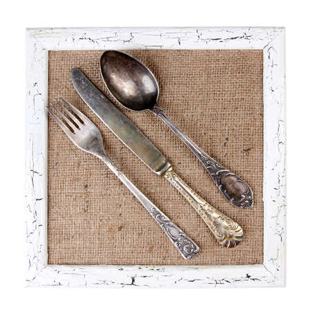 Wooden frame and vintage cutlery  isolated on whiteの写真素材
