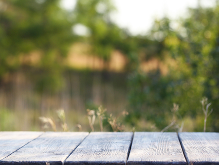 Wooden table with cloth on bright background