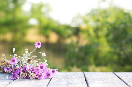 Beautiful wild flowers on table on bright backgroundの写真素材