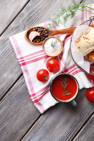 Homemade tomato juice in color mug, bread sticks, spices and fresh tomatoes on wooden backgroundの写真素材