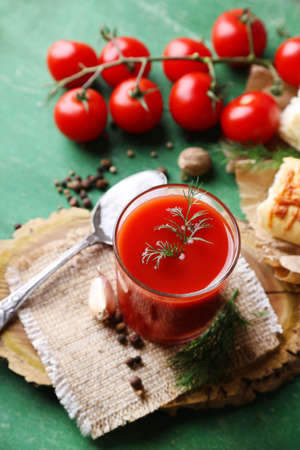 Homemade tomato juice in glass, spices and fresh tomatoes on wooden backgroundの写真素材