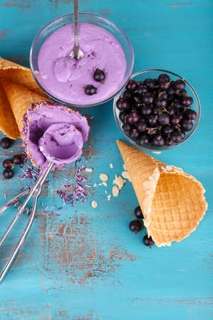 Tasty ice cream with fresh berries on old blue wooden tableの写真素材