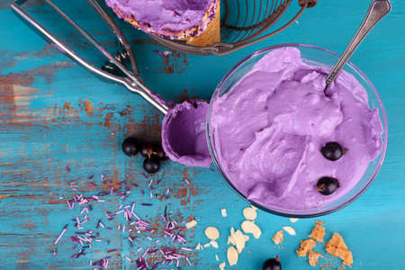 Tasty ice cream with fresh berries on old blue wooden tableの写真素材