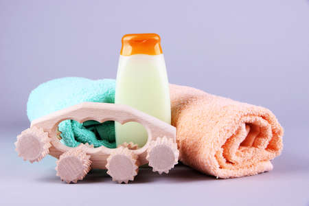 Wooden roller brush, towels and shampoo on grey backgroundの写真素材