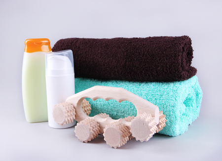 Wooden roller brush, towels and shower kit on grey backgroundの写真素材
