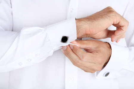 Man in white shirt doing collar button up closeup