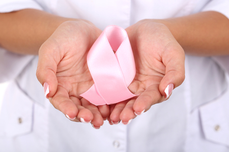 Woman with aids awareness pink ribbon in hands, close-upの写真素材