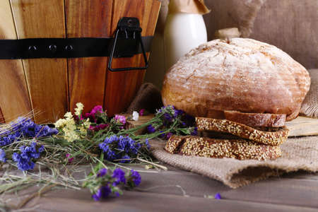 Big wooden basket with dried flowers and milk closeup