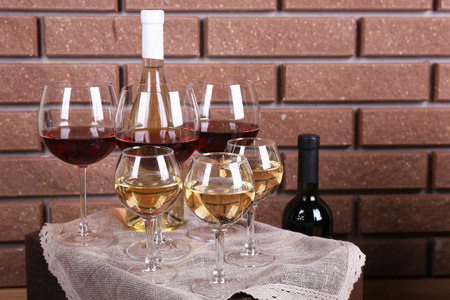 Bottle and glasses of wine on table on brick wall backgroundの写真素材