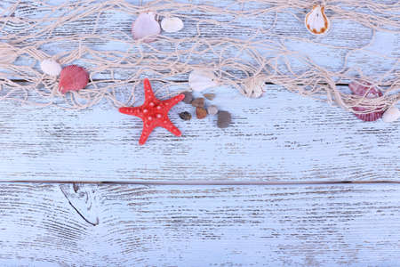 Decor of seashells and seastar close-up on blue wooden tableの写真素材