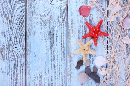 Decor of seashells and seastar close-up on blue wooden tableの写真素材