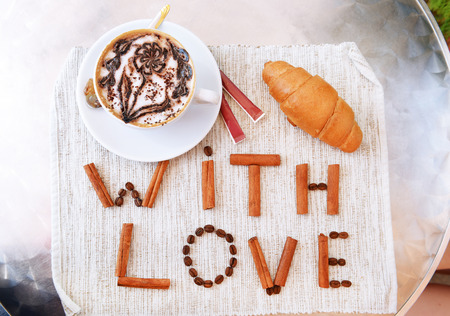 Cup of coffee with cute drawing on table, close upの写真素材