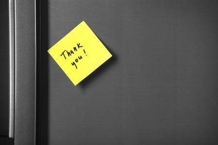 Note on piece of paper on refrigerator closeup