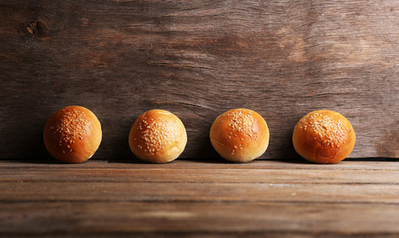Tasty buns with sesame on color wooden backgroundの写真素材