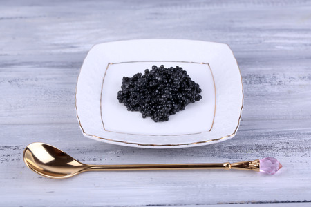 Black caviar on plate on grey wooden backgroundの写真素材