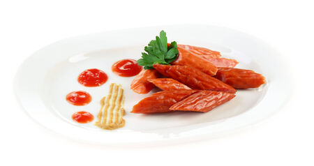 Smoked thin sausages and vegetables on plate, isolated on whiteの写真素材