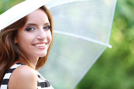 Beautiful young girl with umbrella outdoorsの写真素材