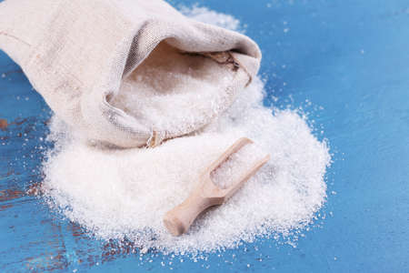 Sugar in bag on color wooden backgroundの写真素材