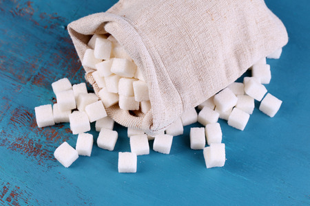 Refined sugar in bag on color wooden backgroundの写真素材