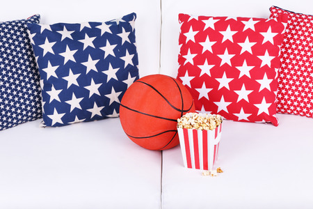Popcorn and basketball on sofa in roomの写真素材