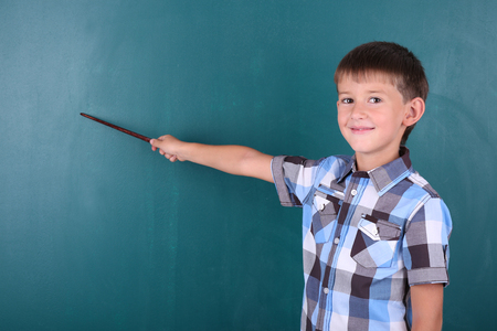 Schoolboy at blackboard in classroomの写真素材