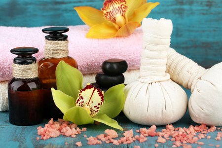 Colorful tropical orchid flowers and spa set on color wooden backgroundの写真素材