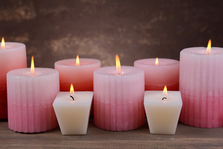 Beautiful candles on table on brown の写真素材