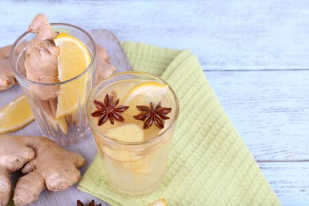 Glasses of ginger drink with lemon on napkin