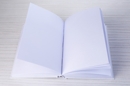 White book on wooden table, close-up