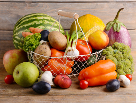 Fresh organic fruits and vegetables on wooden backgroundの写真素材