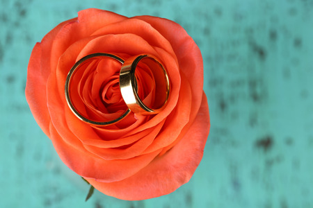 Wedding rings on wedding bouquet, close-up, on color wooden backgroundの写真素材