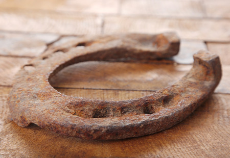Old horse shoe on wooden backgroundの写真素材