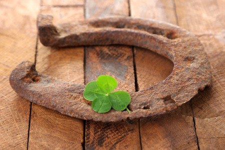 Old horse shoe,with clover leaf, on wooden backgroundの写真素材