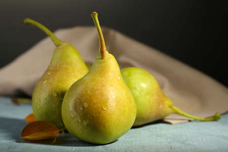 Ripe tasty pears on wooden table, on dark backgroundの写真素材