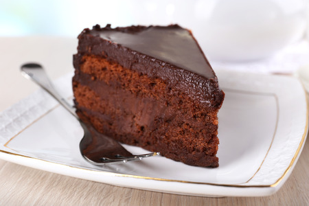 Piece of chocolate cake on saucer on teapot backgroundの写真素材