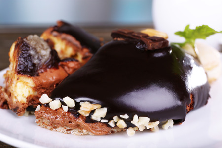 Pieces of chocolate cake on plate and cup of tea on wooden table
