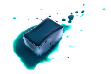 Watercolor paint cube and spilled paint isolated on whiteの写真素材