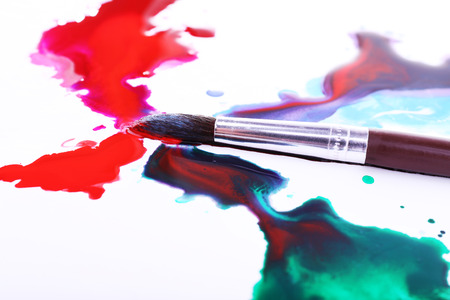 Brush and spilled paint isolated on whiteの写真素材