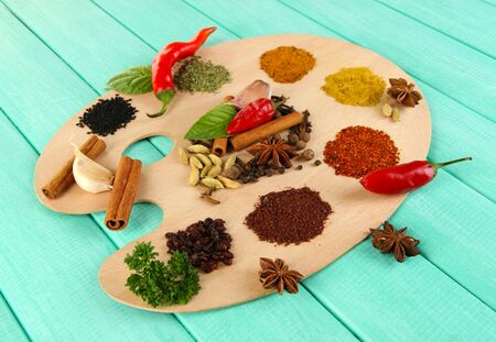 Painting palette with various spices and herbs, on color wooden backgroundの写真素材