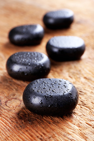 Spa stones with drops on wooden backgroundの写真素材