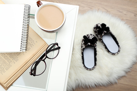 Still life details, cup of coffee, book and glasses on table, on home interior backgroundの写真素材