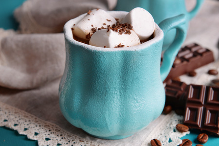 Cup of coffee with marshmallow and chocolate on wooden tableの写真素材