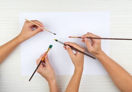 Two girls painting with paintbrush and colorful paintsの写真素材