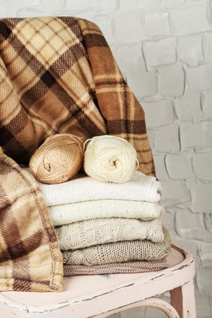 Still life with knitting clothes and yarn on wooden chairの写真素材