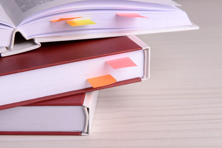Books with bookmarks on wooden table