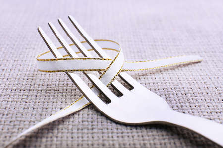 Stages of tying bow on fork, close-upの写真素材