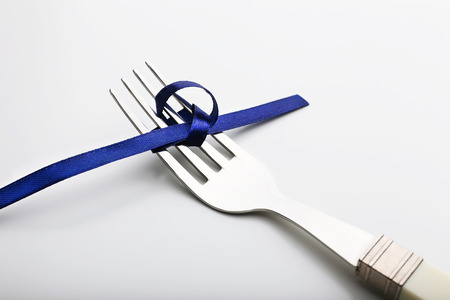 Stages of tying bow on fork close-upの写真素材