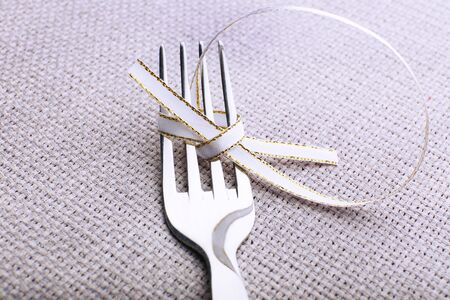 Stages of tying bow on fork, close-upの写真素材