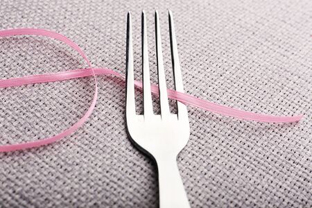 Stages of tying bow on fork, close-upの写真素材